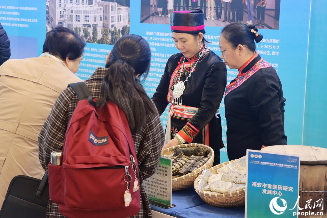 与会嘉宾正在询问“畲家三宝”——菅粽、乌饭、糍粑。人民网 林铭贤摄